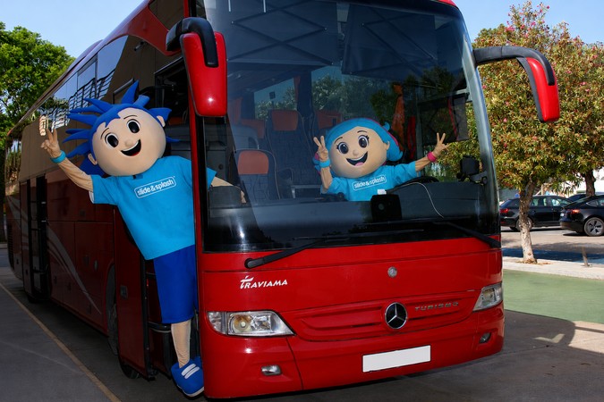 as duas mascotes do Slide&Splash, estão dentro de um autocarro vermelho a fazer uma saudação